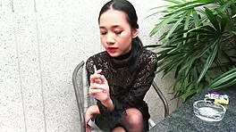 Young girl smokes topless in leather skirt