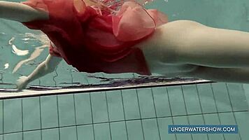 katya okuneva steps into the pool in a red dress, enjoying the outdoor beach scene underwater