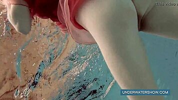 katya okuneva steps into the pool in a red dress, enjoying the outdoor beach scene underwater