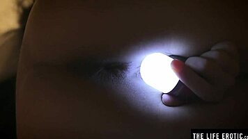 Sleepless girl rubs her trimmed clit under handheld light at night.