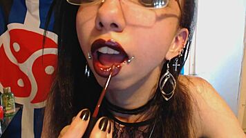 young goth applies dark red lipstick and teases huge puffy nipples