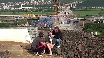 A young blonde cutie gets fucked hard in the street by two guys in a public threesome