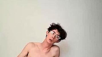 On a sunny day, this horny young teen masturbates with a big cock on the bed, getting cum covered.