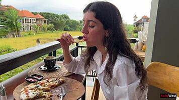 Enjoying a mouthful of pizza on the street in a public cafe with beautiful teen