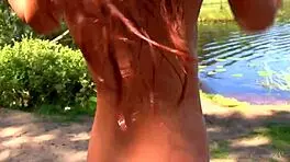 Naked redhead teen plays with water lily