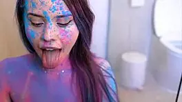 brunette teen covered in colors, getting pleasured with blowjob