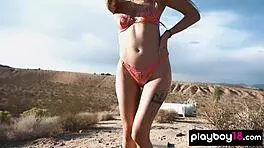 Petite blondie reveals small boobs in desert.