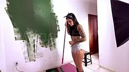 cute young babe drops to suck cock amid paint mess