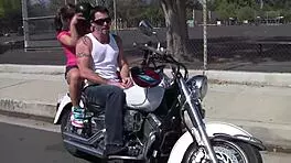 girl cruises on her motorcycle through town