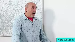 Sexy blonde pours nuru gel rubs natural tits on client 🥵