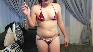 Girl smokes in tiny bikini before stripping nude.