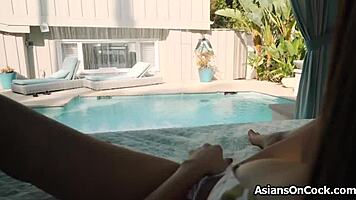 Asian beauty in bikini sucks big black cock by the pool