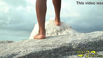 Teen brunette giggles as her feet get wet at the beach on beat2feetcom.