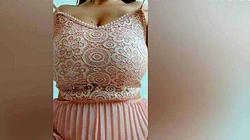 This pretty girl in pink dress plays with her huge natural tits at home!