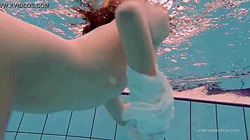 White-dressed tight hairy babe Katy Soroka swims underwater with allure.