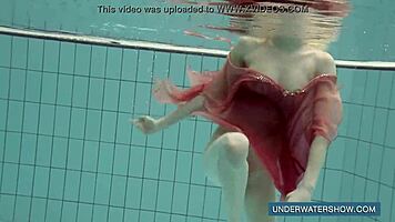 katya okuneva steps into the pool in a red dress, enjoying the outdoor beach scene underwater