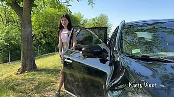 Crazy girl pees on the car roof to clean the windshield.