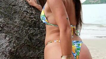 tanned petite brunette flashes bikini on tropical beach